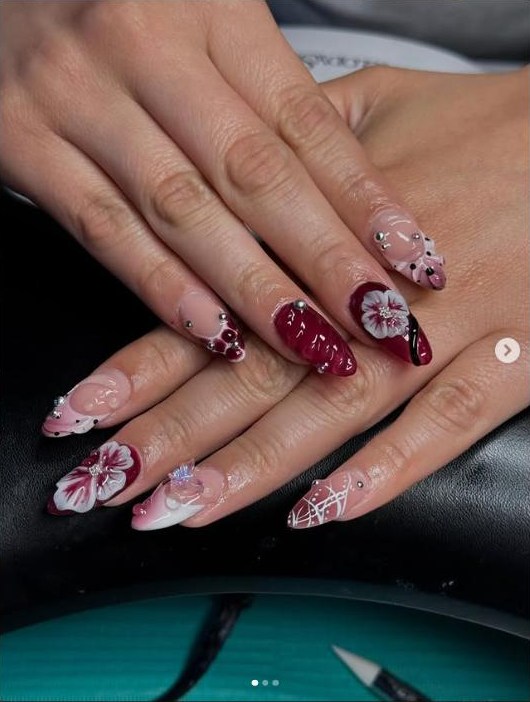 Deep red gel-x set with hand-sculpted white 3D florals and scattered crystals