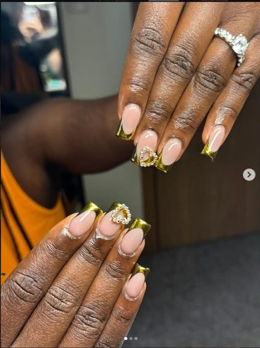 Almond nails with gold chrome french tips and a crystal heart accent